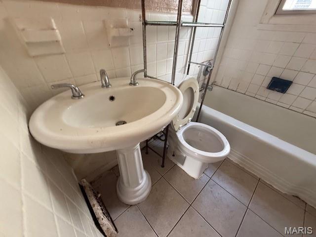 7446 Calvin Ave, Country Club Hills, MO 63136 - full bathroom featuring tile walls, shower / bathtub combination, and tile patterned floors