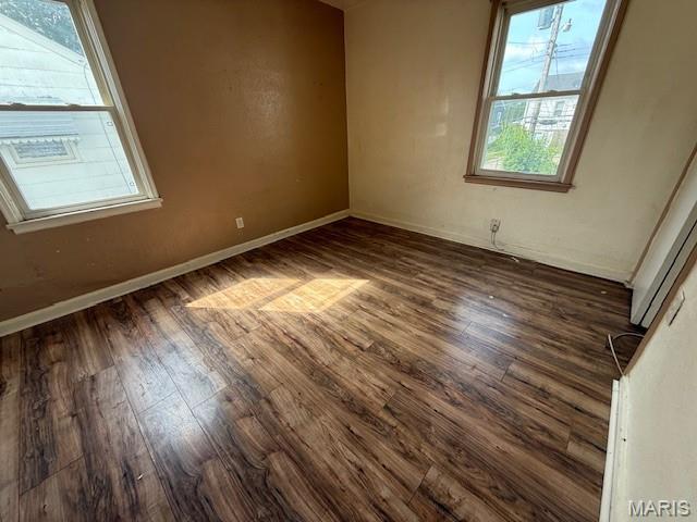 7446 Calvin Ave, Country Club Hills, MO 63136 - empty room featuring dark wood-type flooring and baseboards