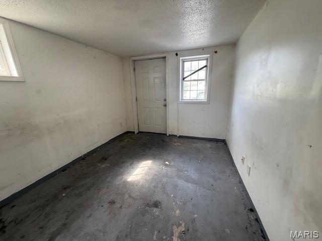 7446 Calvin Ave, Country Club Hills, MO 63136 - unfurnished room with a textured ceiling and unfinished concrete flooring