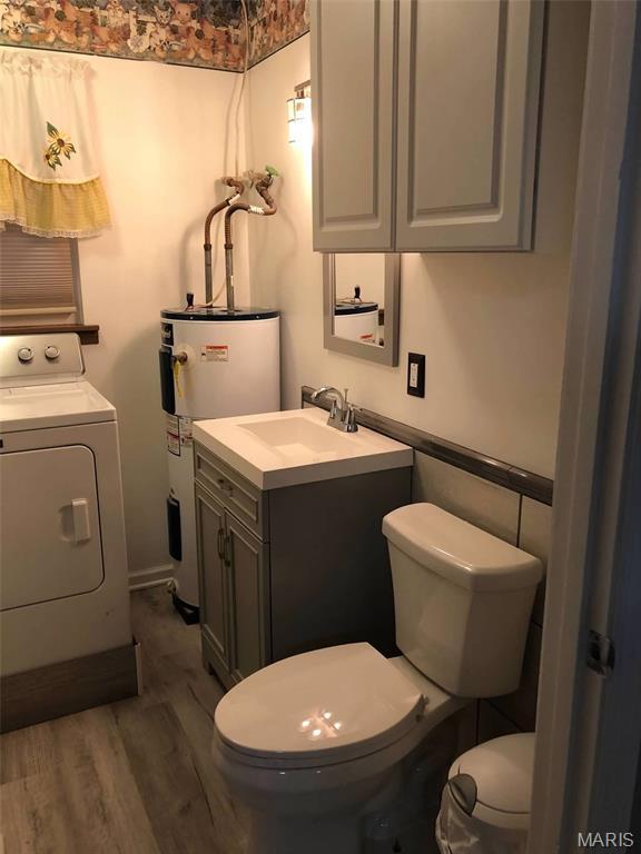 746 State Highway P, New Madrid, MO 63869 - bathroom with washer / dryer, vanity, wood finished floors, and water heater