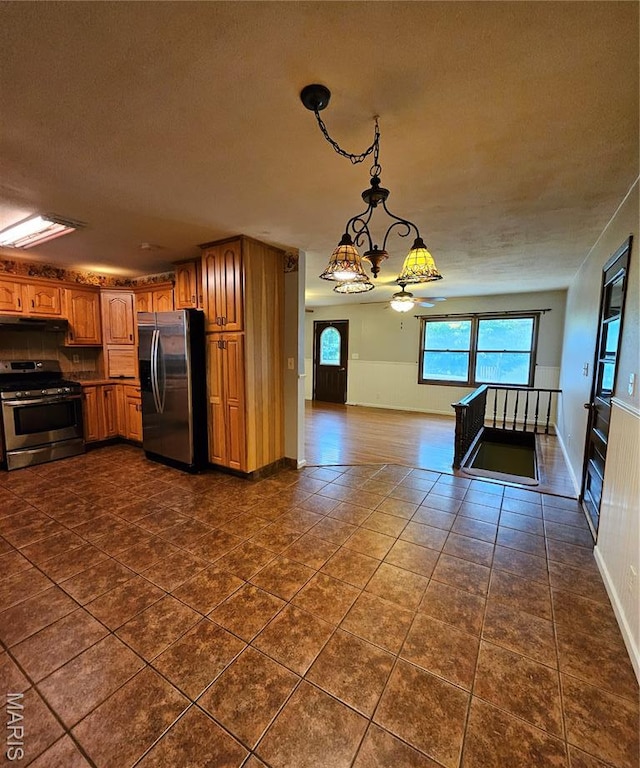 1504 Dean Ave, Hannibal, MO 63401 - kitchen featuring appliances with stainless steel finishes, brown cabinets, a chandelier, open floor plan, and dark tile patterned floors
