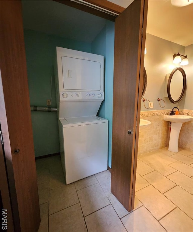 1504 Dean Ave, Hannibal, MO 63401 - washroom featuring stacked washer and clothes dryer, light tile patterned flooring, and tile walls