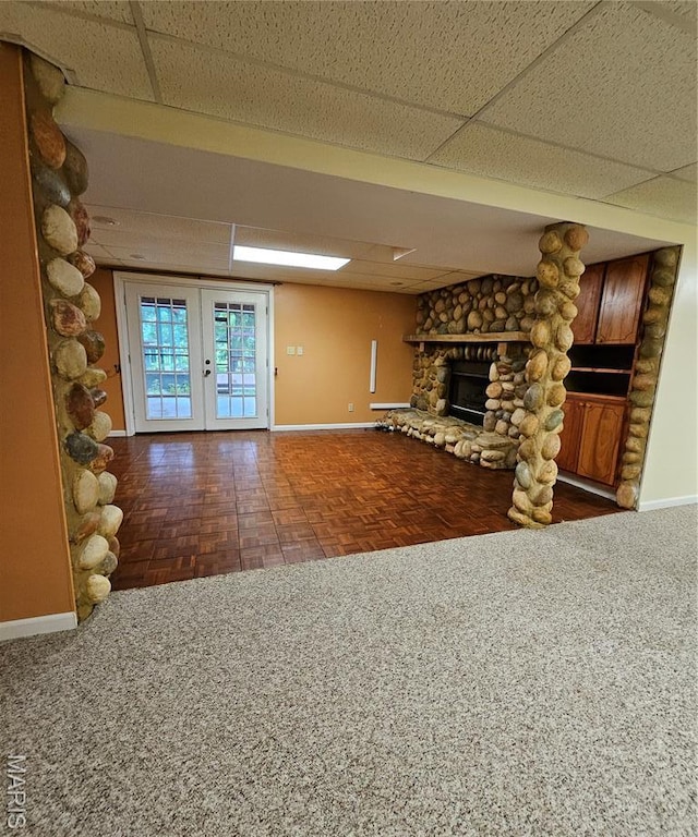 1504 Dean Ave, Hannibal, MO 63401 - unfurnished living room with a stone fireplace, french doors, and a paneled ceiling