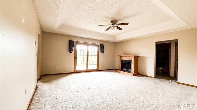 200 April Dr, Saint Robert, MO 65584 - unfurnished living room featuring a raised ceiling, ceiling fan, carpet, a textured ceiling, and a glass covered fireplace