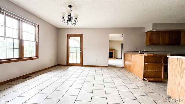 200 April Dr, Saint Robert, MO 65584 - kitchen with plenty of natural light, a textured ceiling, open shelves, a chandelier, and hanging light fixtures