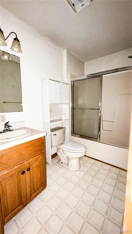 200 April Dr, Saint Robert, MO 65584 - bathroom with vanity, bath / shower combo with glass door, tile patterned floors, and a textured ceiling