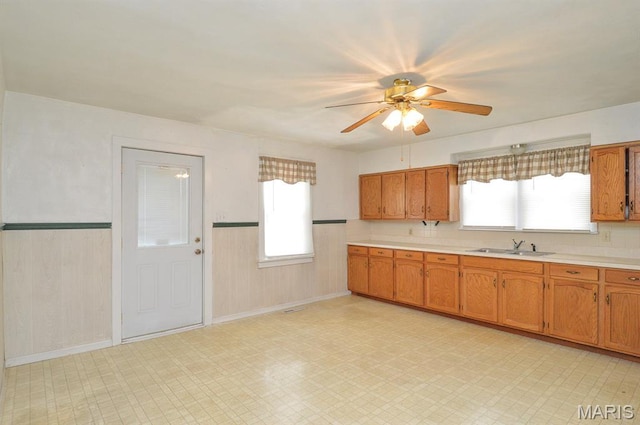 307 S S St, Smithton, IL 62285 - kitchen with light countertops, brown cabinetry, ceiling fan, light floors, and wainscoting