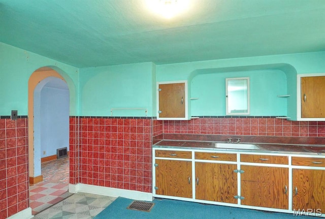 307 S S St, Smithton, IL 62285 - kitchen with stainless steel counters, tile walls, open shelves, arched walkways, and wainscoting