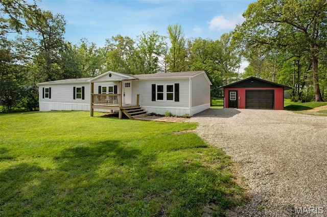 16 Garrett Ln, Defiance, MO 63341 - manufactured / mobile home with an outbuilding, a garage, a front lawn, driveway, and view of wooded area