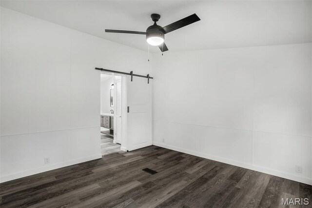 16 Garrett Ln, Defiance, MO 63341 - spare room featuring a barn door, dark wood-style flooring, and ceiling fan