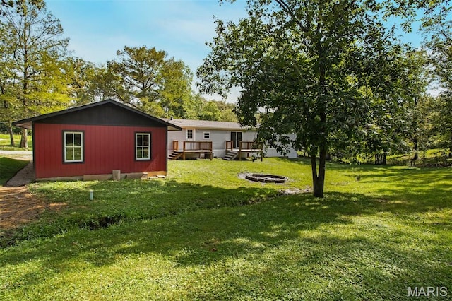 16 Garrett Ln, Defiance, MO 63341 - view of grassy yard featuring a fire pit and a wooden deck