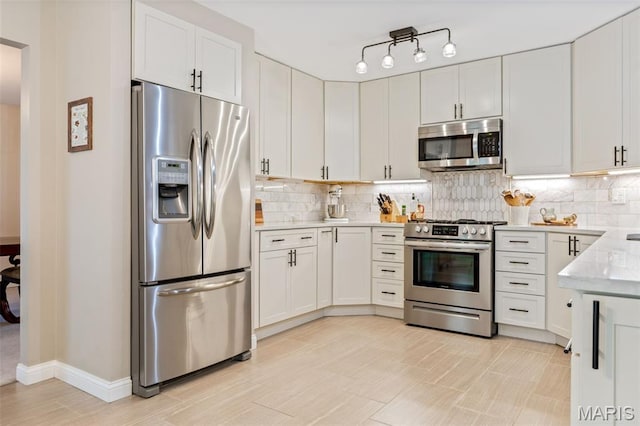 14 Greystoke Ct, Ballwin, MO 63021 - kitchen with appliances with stainless steel finishes, decorative backsplash, white cabinetry, and light stone countertops