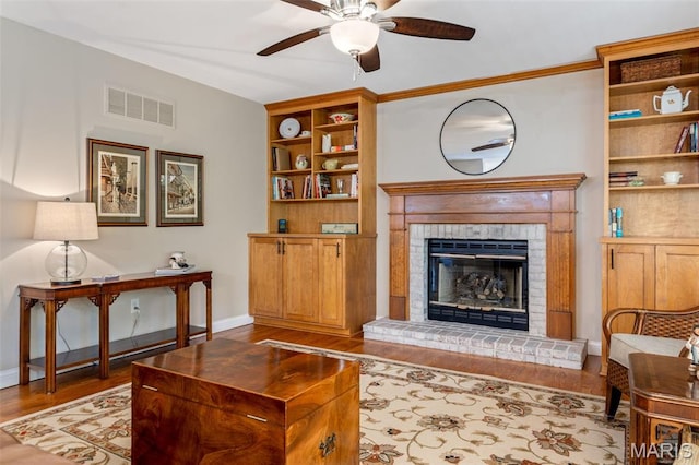 14 Greystoke Ct, Ballwin, MO 63021 - living area featuring ceiling fan, wood finished floors, a brick fireplace, and built in shelves