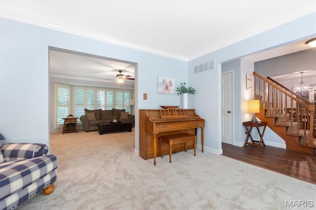 1008 Westrun Dr, Ballwin, MO 63021 - carpeted living area with stairway, crown molding, a chandelier, and a ceiling fan