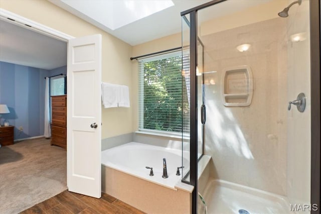 1008 Westrun Dr, Ballwin, MO 63021 - full bathroom with a shower stall, a bath, a skylight, and wood finished floors