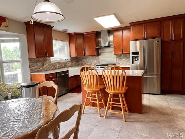 3241 Principia Ave, Saint Charles, MO 63301 - kitchen with wall chimney range hood, stainless steel appliances, a kitchen island, tasteful backsplash, and a kitchen breakfast bar