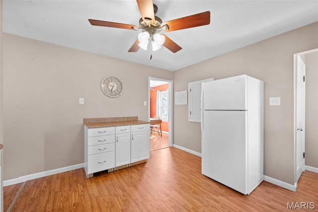 10256 Saint Dennis Ln, Saint Ann, MO 63074 - kitchen with freestanding refrigerator, a ceiling fan, light wood-style flooring, and white cabinetry