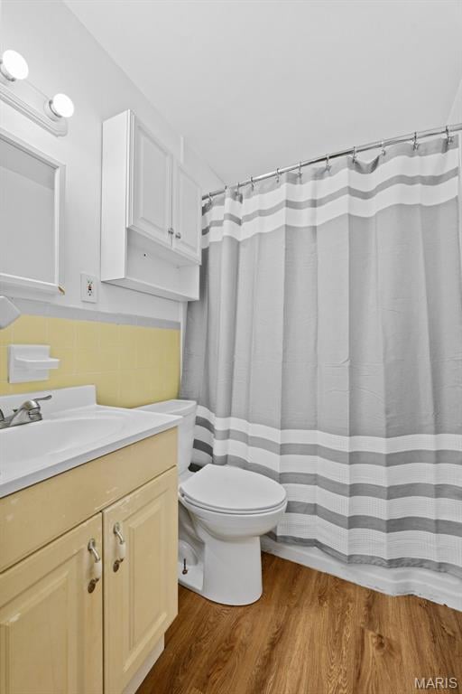10256 Saint Dennis Ln, Saint Ann, MO 63074 - full bath with vanity, wood finished floors, tile walls, and a shower with curtain