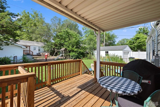 10256 Saint Dennis Ln, Saint Ann, MO 63074 - wooden deck with a fenced backyard, a playground, area for grilling, an outbuilding, and outdoor dining area
