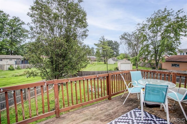 7800 Chuck Ct, Godfrey, IL 62035 - wooden deck featuring a fenced backyard, outdoor dining space, and an outbuilding