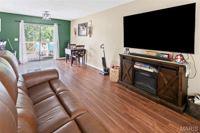 7800 Chuck Ct, Godfrey, IL 62035 - living area featuring wood finished floors, a textured ceiling, and a glass covered fireplace