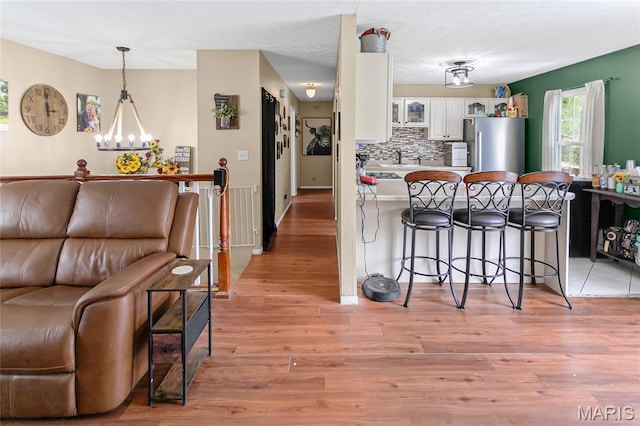 7800 Chuck Ct, Godfrey, IL 62035 - kitchen with freestanding refrigerator, a kitchen breakfast bar, a peninsula, white cabinetry, and open floor plan