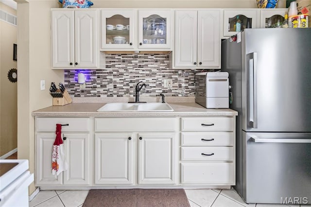 7800 Chuck Ct, Godfrey, IL 62035 - kitchen with freestanding refrigerator, light tile patterned flooring, and white cabinetry