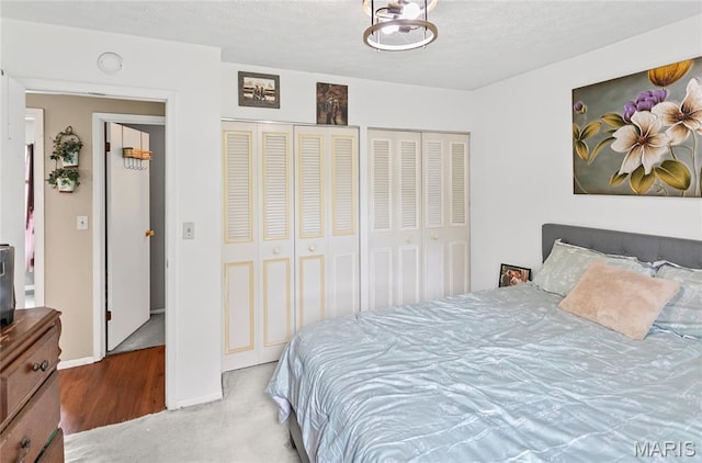 7800 Chuck Ct, Godfrey, IL 62035 - bedroom featuring multiple closets, a textured ceiling, and carpet