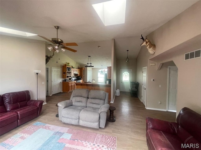 17035 Lanes End, Dixon, MO 65459 - living area featuring lofted ceiling, a skylight, light wood-style flooring, and a ceiling fan