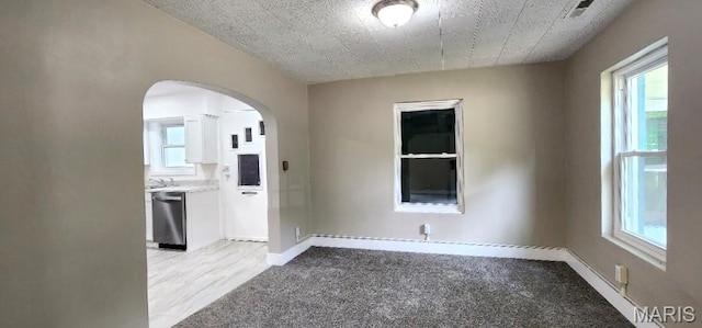 115 N 5th St, De Soto, MO 63020 - empty room with arched walkways and light carpet