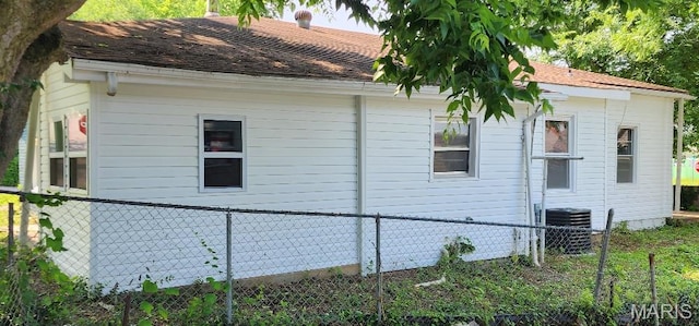 115 N 5th St, De Soto, MO 63020 - view of side of property featuring a central air condition unit and a shingled roof