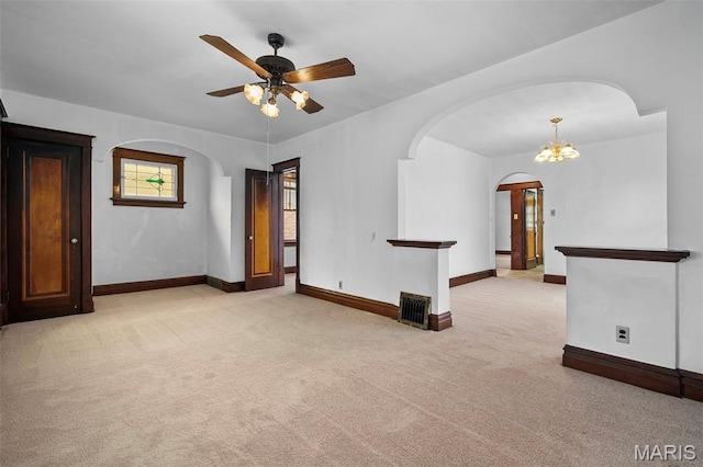 887 Wall St, Saint Louis, MO 63147 - spare room featuring arched walkways, a ceiling fan, and light colored carpet