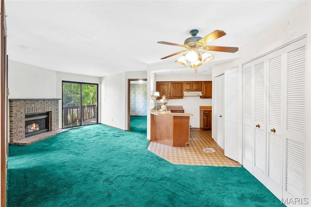 1514 Summer Run Dr Unit 208, Florissant, MO 63033 - kitchen with brown cabinets, carpet floors, open floor plan, ceiling fan, and a brick fireplace