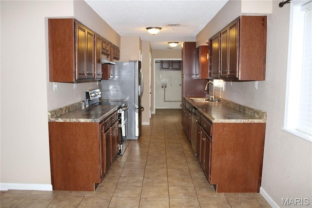 17576 Rigdon St, Kennett, MO 63857 - kitchen with electric stove, under cabinet range hood, light tile patterned floors, and a textured wall