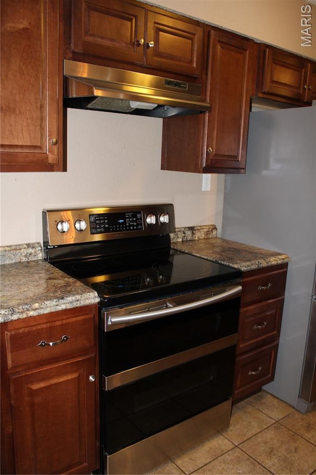 17576 Rigdon St, Kennett, MO 63857 - kitchen with range with two ovens, under cabinet range hood, freestanding refrigerator, and light tile patterned flooring