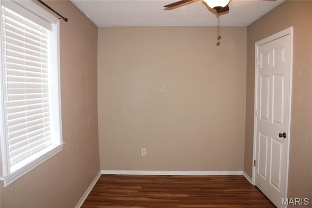 17576 Rigdon St, Kennett, MO 63857 - empty room with ceiling fan, dark wood-style floors, healthy amount of natural light, and a textured ceiling