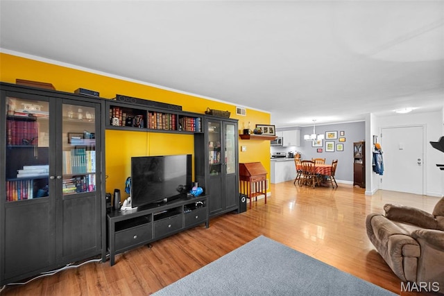 1400 Heritage Lndg Unit 109, Saint Charles, MO 63303 - living area featuring light wood-style flooring, a chandelier, and crown molding