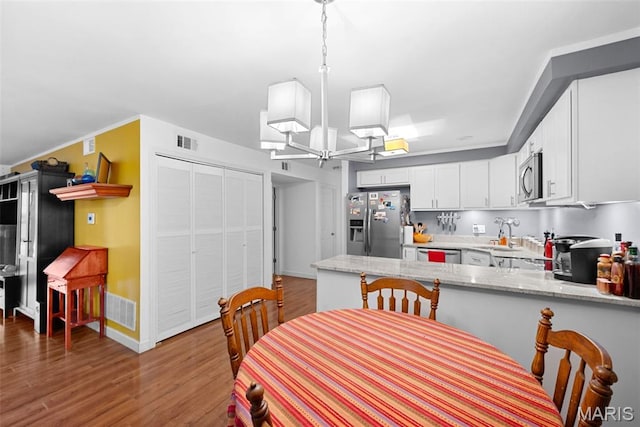 1400 Heritage Lndg Unit 109, Saint Charles, MO 63303 - dining space with wood finished floors and a chandelier