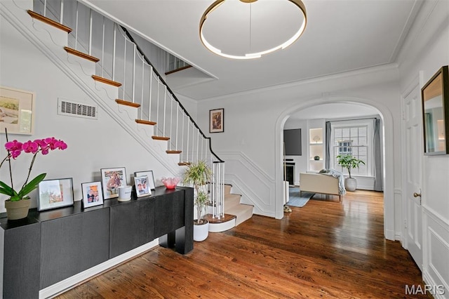 20 Ridgemoor Dr, Clayton, MO 63105 - entrance foyer featuring arched walkways, crown molding, stairway, a decorative wall, and wood finished floors