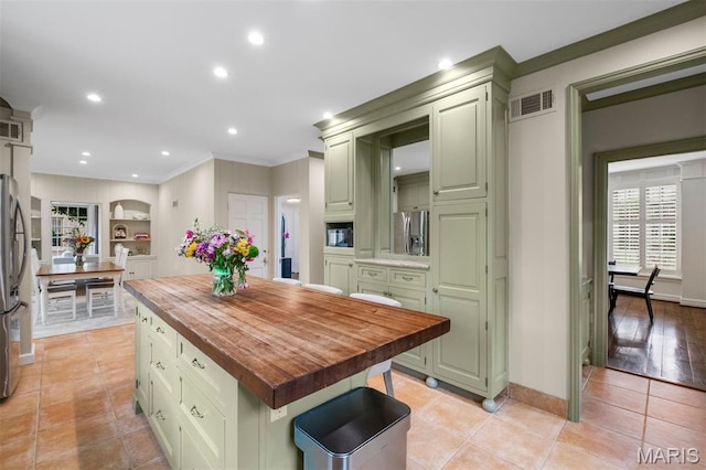 20 Ridgemoor Dr, Clayton, MO 63105 - kitchen with green cabinets, wood counters, ornamental molding, a kitchen island, and light tile patterned floors