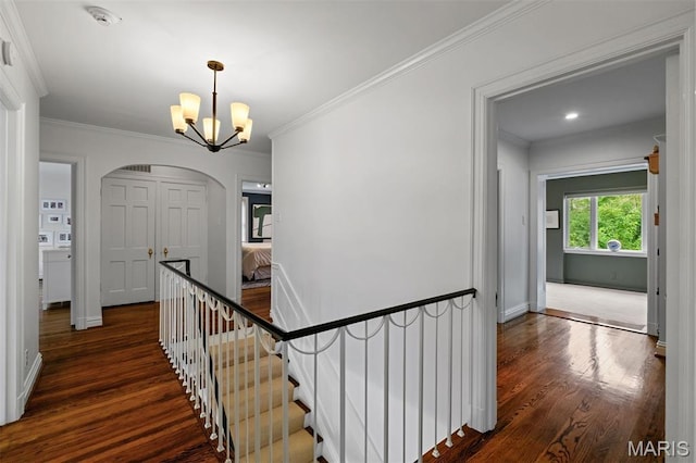 20 Ridgemoor Dr, Clayton, MO 63105 - hall with dark wood finished floors, a chandelier, arched walkways, an upstairs landing, and crown molding