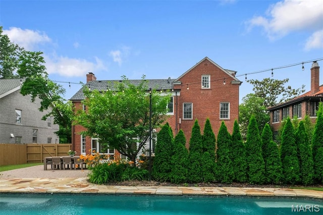 20 Ridgemoor Dr, Clayton, MO 63105 - back of property featuring a patio, brick siding, and a chimney