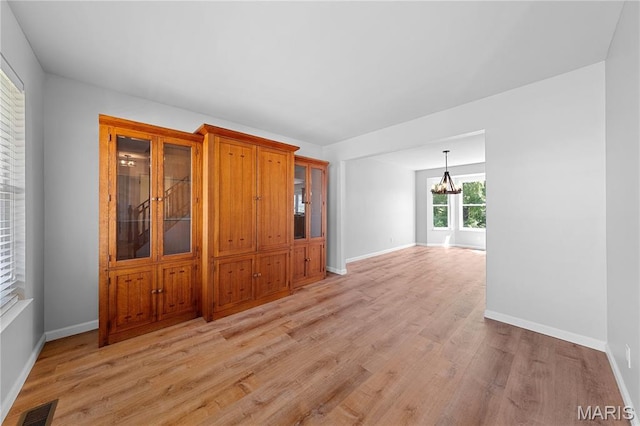 3924 Cambridge Crossing Dr, Saint Charles, MO 63304 - empty room with light wood-style flooring and a chandelier