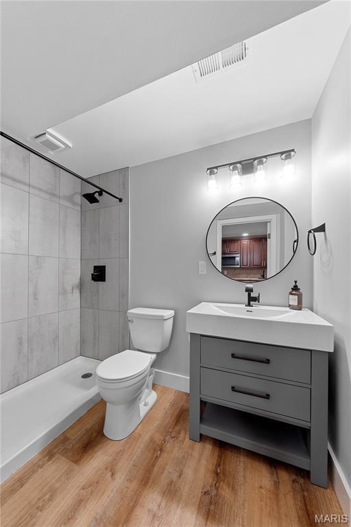 3924 Cambridge Crossing Dr, Saint Charles, MO 63304 - full bath featuring vanity, wood finished floors, and tiled shower