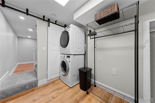 3924 Cambridge Crossing Dr, Saint Charles, MO 63304 - laundry room with stacked washer and clothes dryer, a barn door, recessed lighting, and light wood-style floors