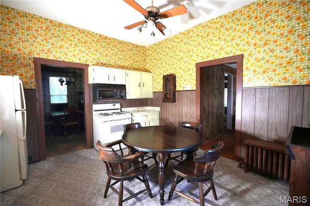 114 W 2nd St S, Mount Olive, IL 62069 - dining room with wallpapered walls, a wainscoted wall, a ceiling fan, and wooden walls