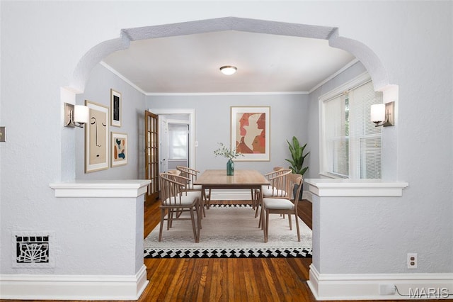 6162 W Park Ave, Saint Louis, MO 63139 - dining room featuring crown molding, dark wood-style flooring, plenty of natural light, arched walkways, and a textured wall