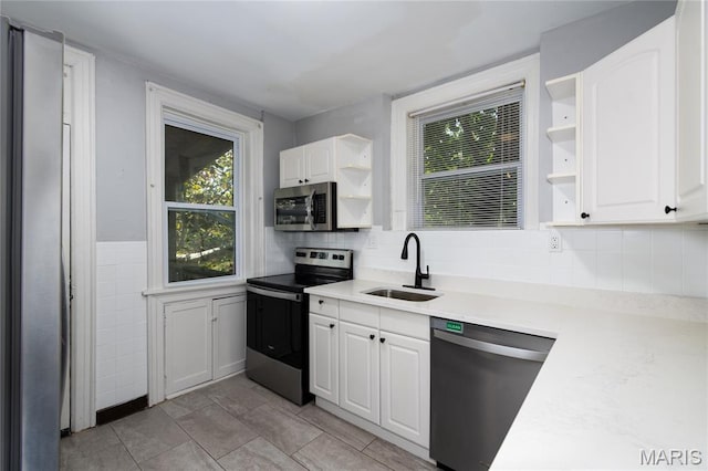 6162 W Park Ave, Saint Louis, MO 63139 - kitchen with stainless steel appliances, open shelves, white cabinetry, light countertops, and decorative backsplash