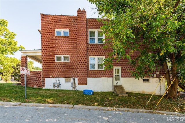 6162 W Park Ave, Saint Louis, MO 63139 - view of property exterior featuring a lawn, brick siding, entry steps, and a chimney
