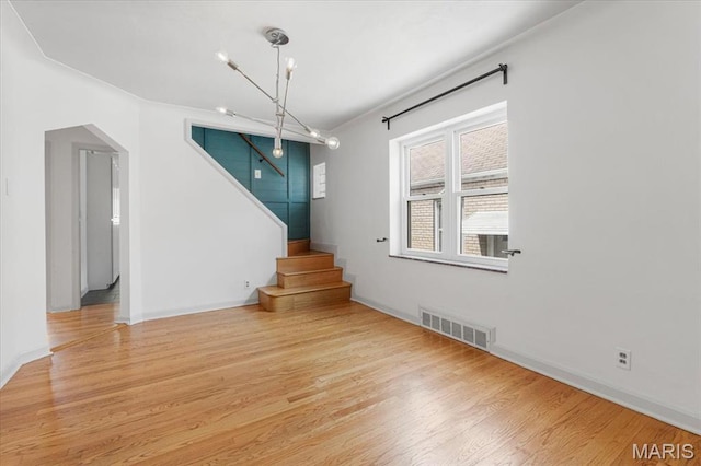 5660 Oleatha Ave, Saint Louis, MO 63139 - empty room featuring stairs, wood finished floors, and arched walkways